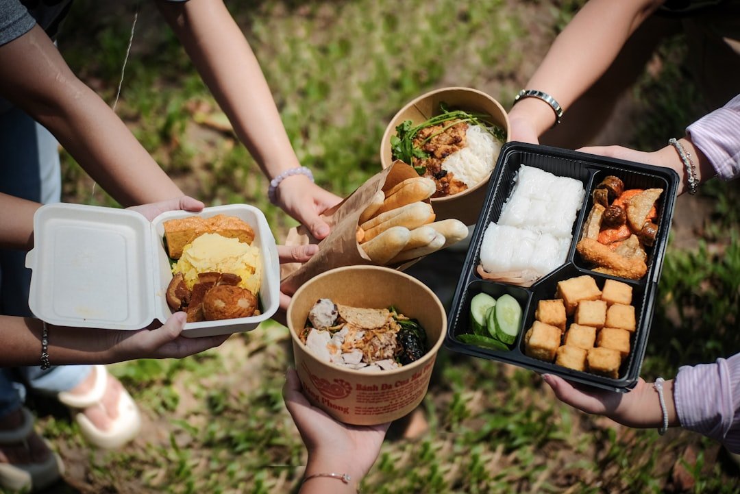 a-group-of-people-holding-trays-of-food-er1jkahfe4w